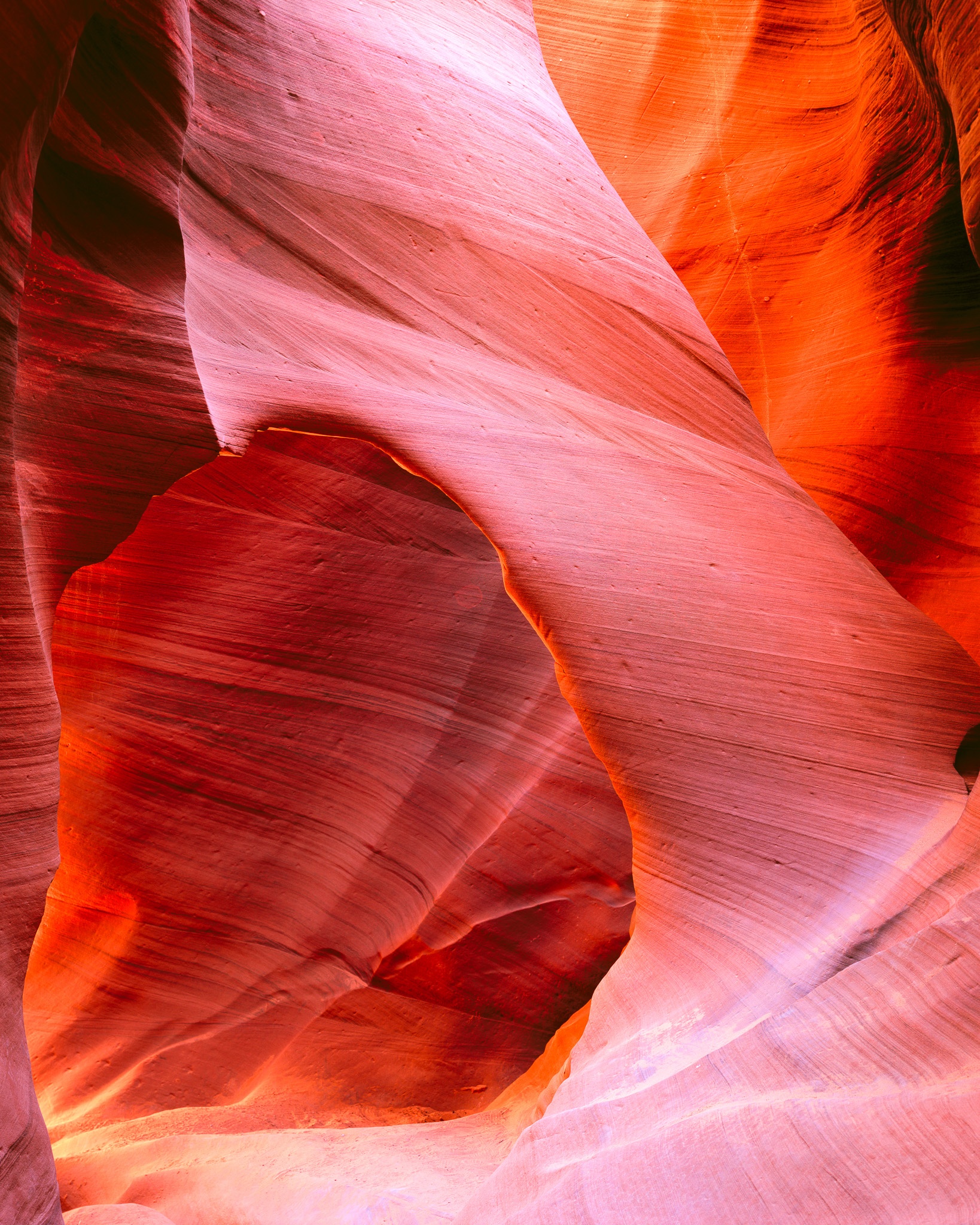 Inside Lower Antelope Canyon, an arch of sandstone frames the passage beyond, Arizona. Photograph by Marty Quinn