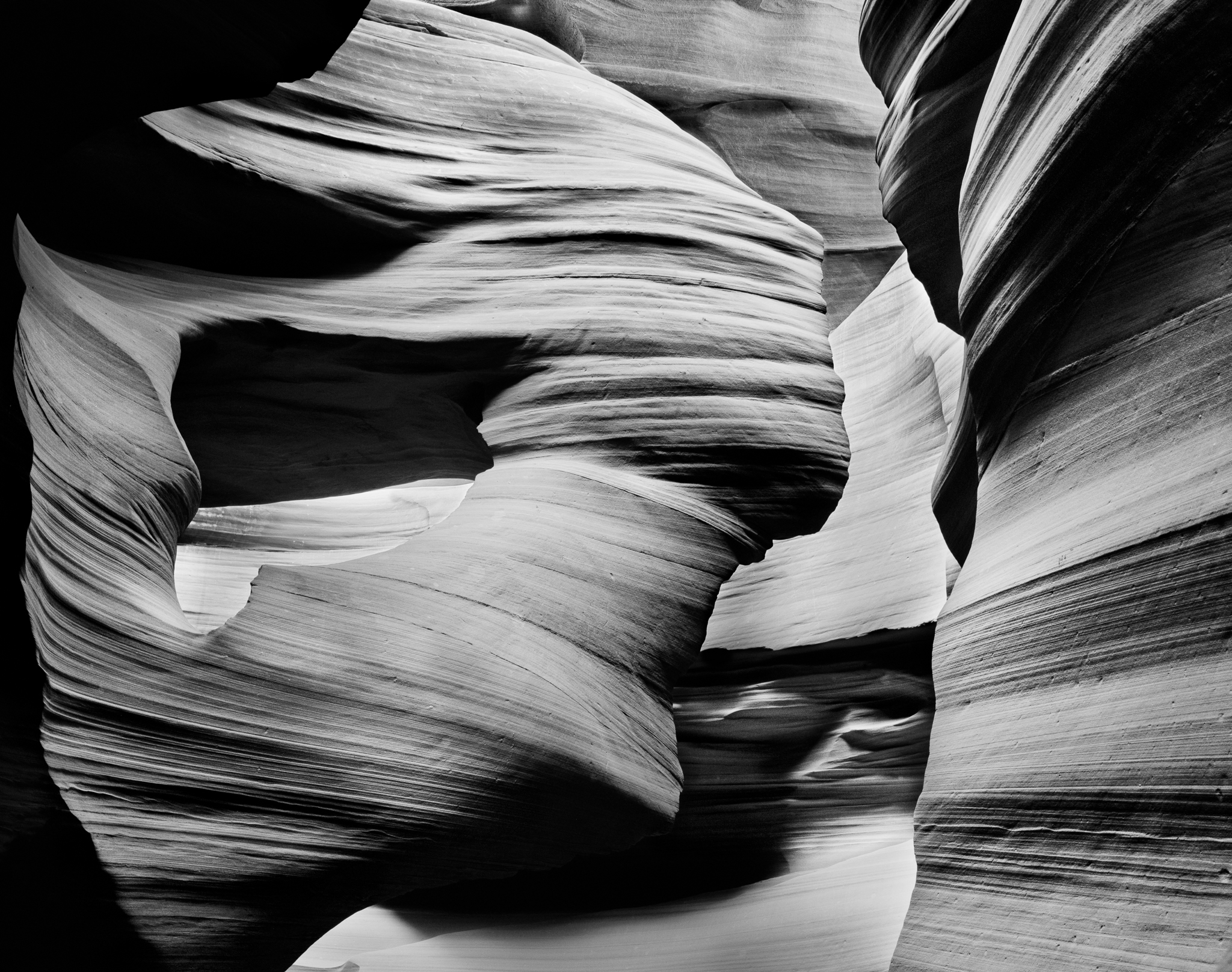 Inside Lower Antelope Canyon, the swirling sandstone walls frame a rock formation that reads unmistakably as a woman's bust in profile — head, neck, shoulders — carved by water and left there, Arizona. Photograph by Marty Quinn