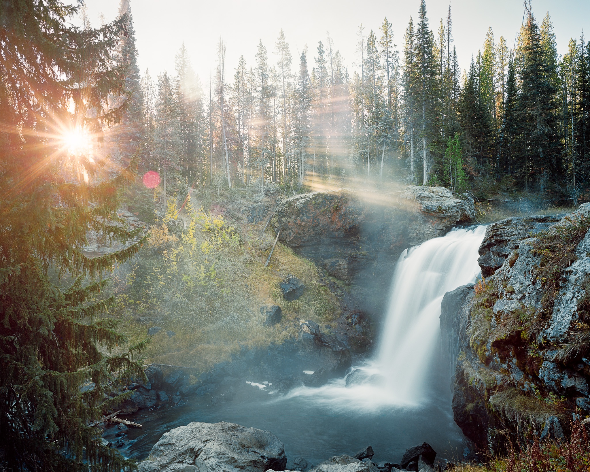 This New Mexico waterfall was photographed in October, early enough that the mist was still lifting off the water when the first shaft of light broke through the forest canopy. Photograph by Marty Quinn