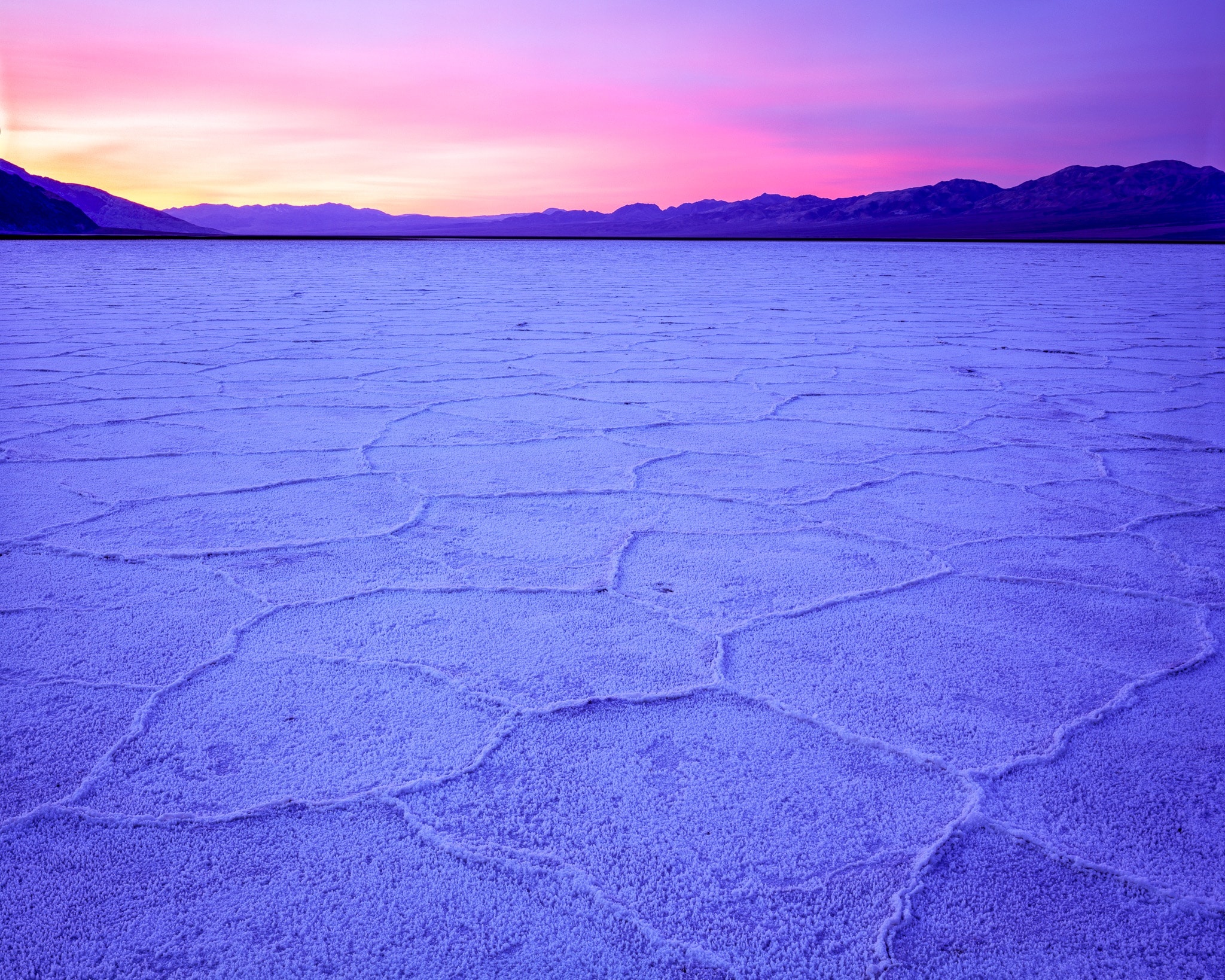 Pink clouds at sunrise over Death Valley's salt flats, shot on Fujichrome Velvia 50 with an Arca-Swiss 4x5 field camera, California. Photograph by Marty Quinn